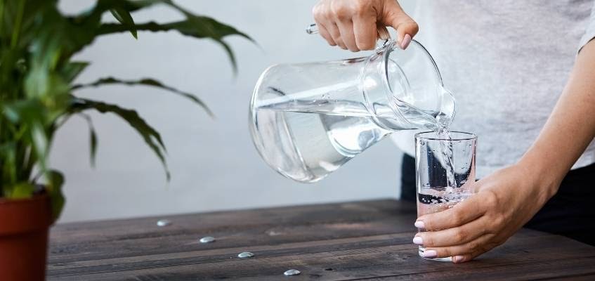 Чистая вода — лучший напиток Человек наливают воду в стакан