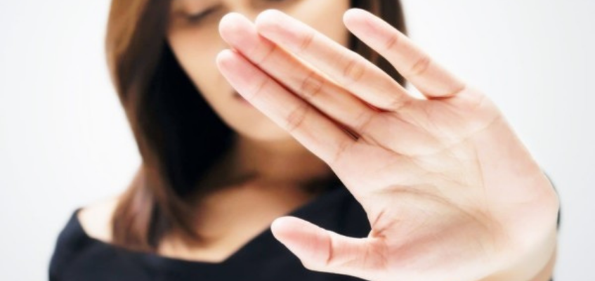 Женщина закрывает лицо рукой