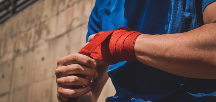 Мужчина заматывает руку