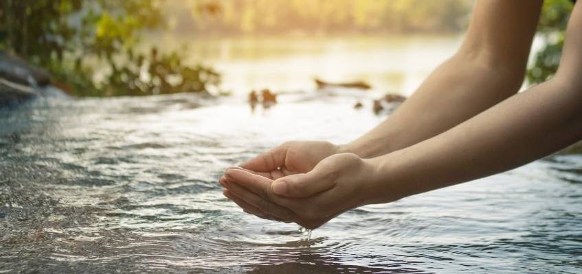 Человек набирает воду в ладони