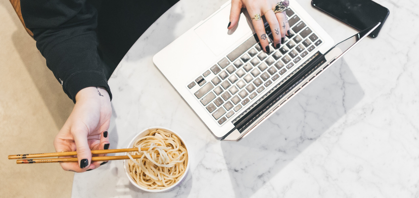 Перекус за работой — плохая идея Женщина ест за ноутбуком