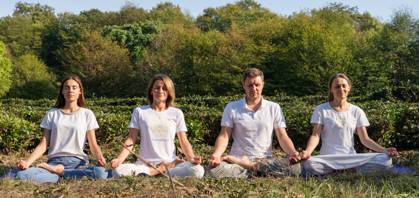 Люди медитируют на траве