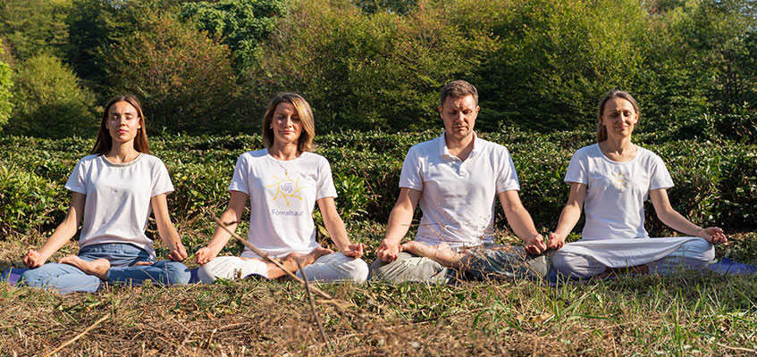 Медитация Люди сидят на траве и медитируют